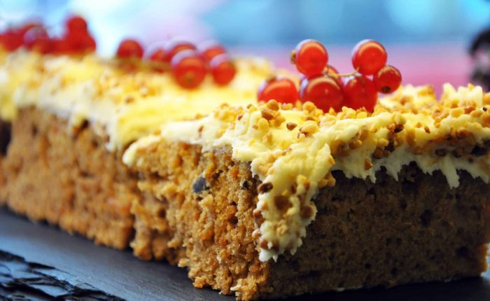 Carrot cake slice with cream cheese and red berries